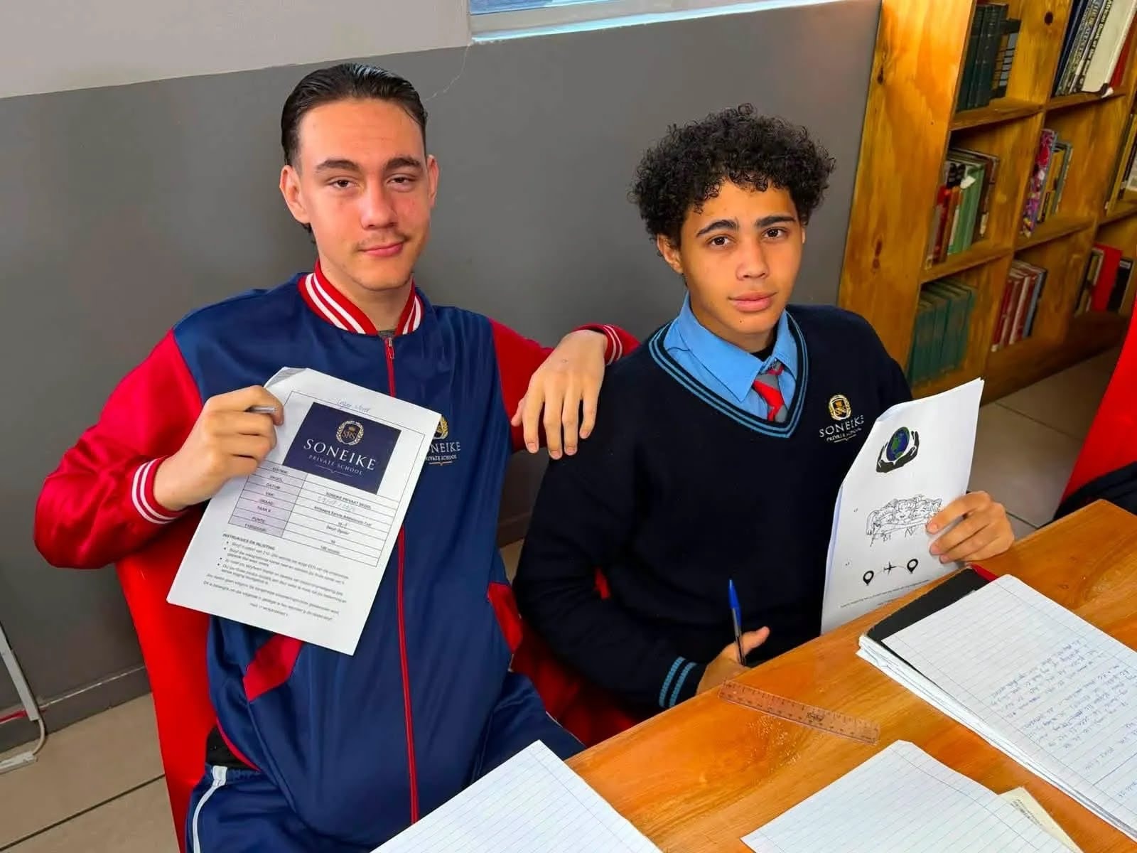 Soneike learners studying with worksheets in the school library
