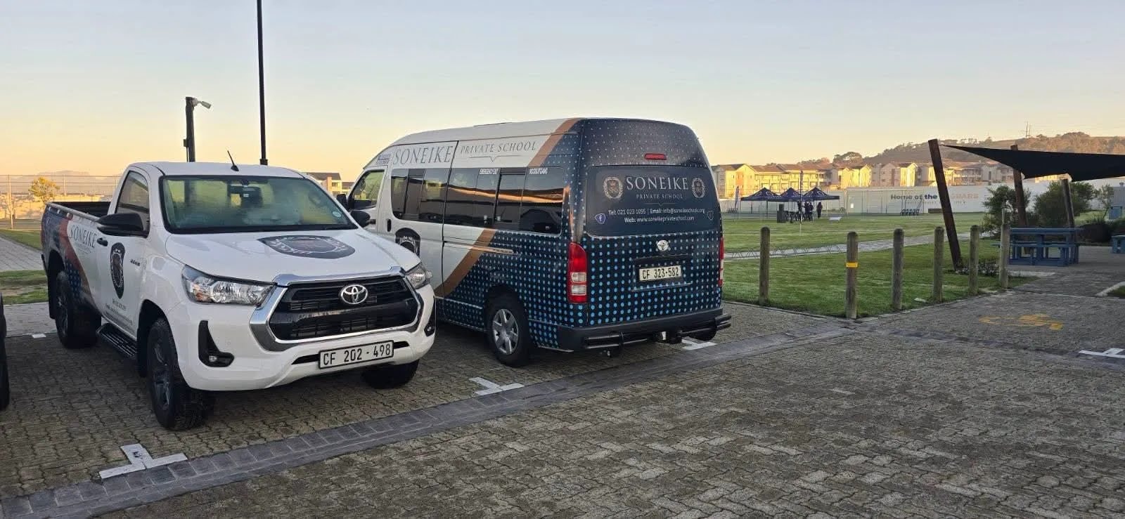 Soneike Private School branded fleet — Toyota Hilux bakkie and school minibus parked at campus